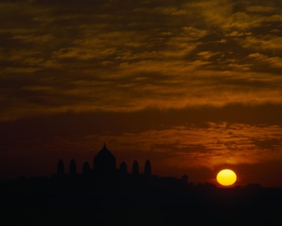 INDIA, Rajasthan, Jodphur, Umaid Bhawan Palace seen at sunset with orange setting sun