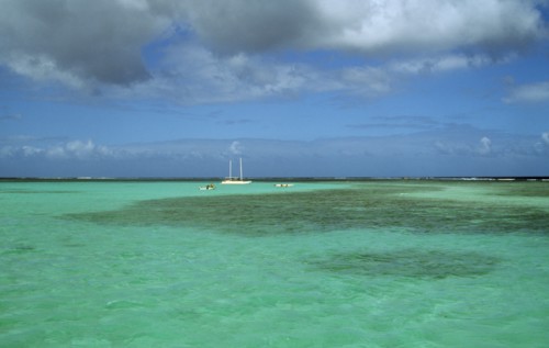 WEST INDIES, Tobago, Buccoo Reef, The Nylon Pool with yacht anchored on the horizon