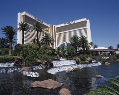 USA, Nevada, Las Vegas, Mirage Hotel and Casino. View across waterfall and palm tree lined rock