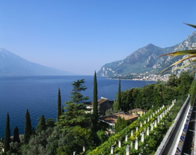 ITALY, Lake Garda,  Limone, "View over roof tops to lake, town to far right, distant hills, blue