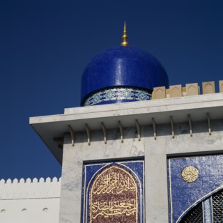 OMAN, Capital Area, Muscat, Khor Mosque. Detail of blue dome and Arabic inscription on wall