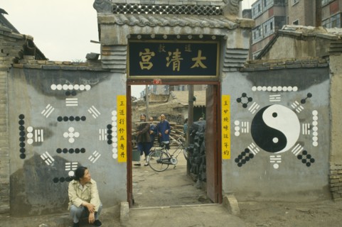 MONGOLIA, Religion, Buddhism, Yin and Yang painting on wall with woman sat on ground looking up at
