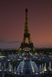 FRANCE, Ile De France, Paris, Eiffel Tower illuminated at dusk with illuminated fountains in the