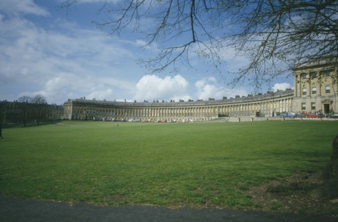 ENGLAND, Avon , Bath, "The Royal Crescent across grass area, budding branches frame "