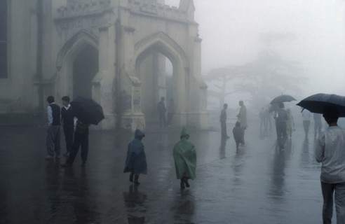 WEATHER, Rain, Monsoon rain falling in Simla India with people walking with umbrellas and children