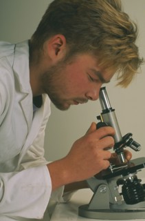 HEALTH, Science, Technichian looking through a microscope
