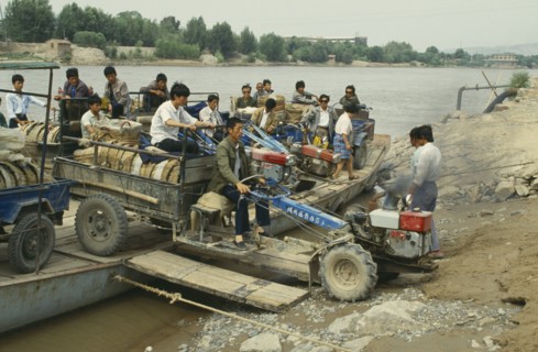 CHINA, Yellow River, Men taking a tractor off a ferry