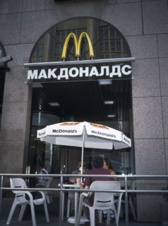 RUSSIA, Moscow, McDonalds Restaurant with people sitting at table and chairs with umbrella outside