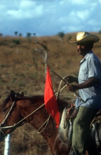 CUBA, Sancti Spiritus, Man on horseback carrying red flag