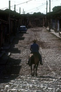 CUBA, Sancti Spiritus, Trinidad, Man riding horse on cobbled street