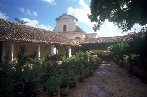 CUBA, Sancti Spiritus, Trinidad, View over plant lined courtyard toward church building