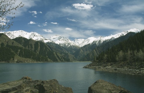 CHINA, Xinjiang, Lake Tianchi, Heavenly Lake with snow capped mountains