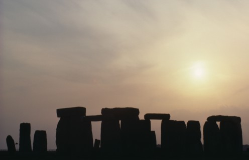 ENGLAND, Wiltshire, Stonehenge, Standing stones on Salisbury Plain silhouetted at sunset with a