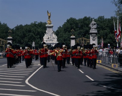 ENGLAND, London, Pageantry Marching guards band with The Victoria Memorial behind. Union Jack flags