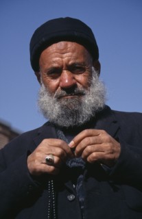 IRAN, Tabriz  , Portrait of an elderly man dressed in black with prayer beads