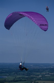 10127601 SPORT  Air Paragliding Paraglider with purple chute and landscape below.