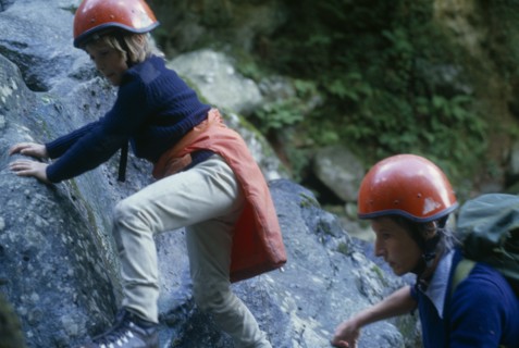 10127733 SPORT  Climbing Woman and child rock climbing wearing red safety helmets in North Wales