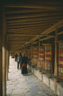 CHINA, Gansu Province, Labrang Monastery, Tibetan pilgrims turning prayer wheels.