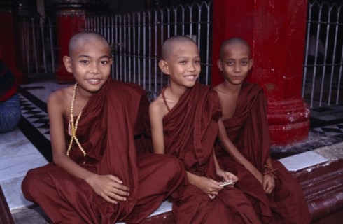 MYANMAR, Yangon, Shwedagon Pagoda, Three young monks sitting on the floor at the front of the