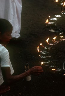 SRI LANKA, Anuradhapura, People lighting lamps during Wessac