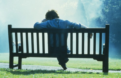 HEALTH, Emotional, Thoughtful single man sitting on park bench in slumped posture.