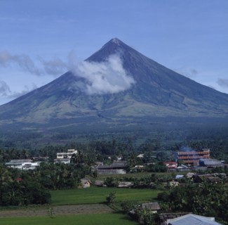 PHILIPPINES, Luzon Island, Legaspi, Mayon volcano with wispy cloud and village at the base