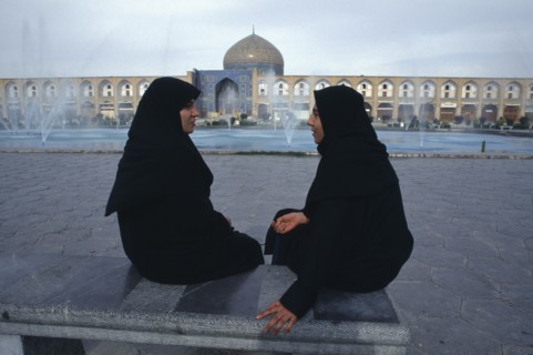 IRAN,  , Esfahan, Emam Khomeini Square Two women talking Sheikh Lot Fallah mosque in background
