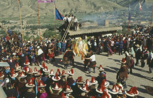 CHINA, Quinghai, Tongren, Tibetan festival with people wearing red tassled hats