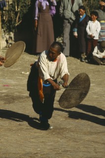CHINA, Tibet, Dancer beating a hide drum at a festival