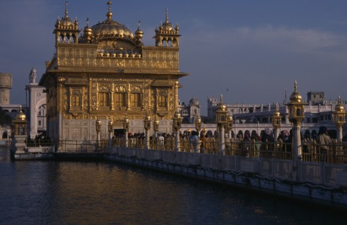 INDIA, Punjab, Amritsar, Golden Temple. Pilgrims and visitors on causeway known as the Guru’s