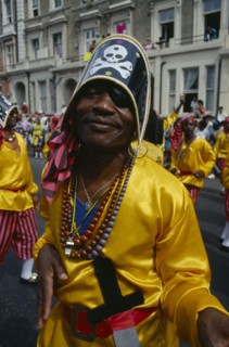 ENGLAND, London, Notting Hill Carnival man dressed as a pirate with yellow shirt and skull and
