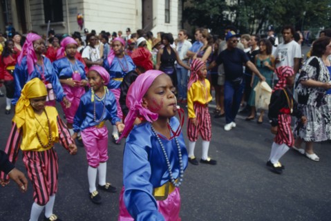 ENGLAND, London, Notting Hill Carnival. Children in costume blowing whistles during parade.