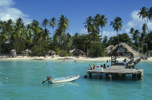 WEST INDIES, Tobago, Pigeon Point, Boat jetty and beach from the sea with tourists sunbathing and