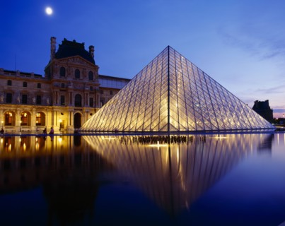 FRANCE, Ile de France, Paris, Louvre.  Glass pyramid and surrounding buildings floodlit at night