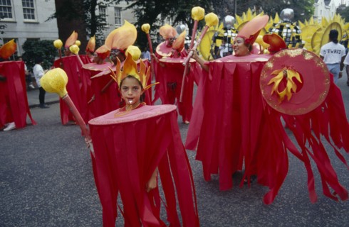 ENGLAND, London, "Notting Hill  Carnival. Little girl in red costume and flame shaped head-dress,