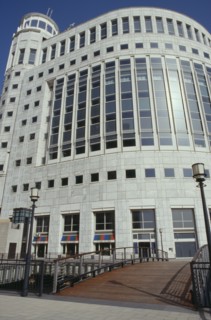 ENGLAND, London, Round sided office block with shops on the ground floor near Canary Wharf