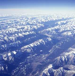 USA, Montana, Glacier National Park, The snow covered Rocky Mountains with a thin layer of cloud