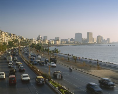 INDIA, Maharashtra, Bombay, "Marine Drive at dusk,cars on dual carriageway, skyscrapers beyond "