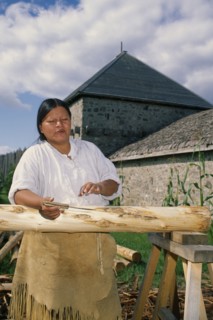 CANADA, Ontario, Sainte Marie, Ojibway Indian woman stripping the bark from trees