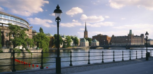 SWEDEN, Stockholm, View from path across water towards waterfront buildings.