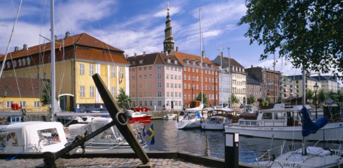 DENMARK, Copenhagen, Boats moored on Christianshavn canal with city buildings behind.