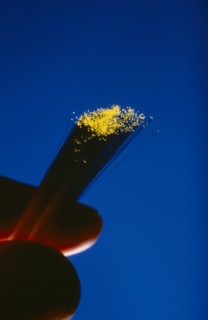 COMMUNICATIONS, Fibre Optics, Fibre optics cables with illuminated ends being held between a thumb