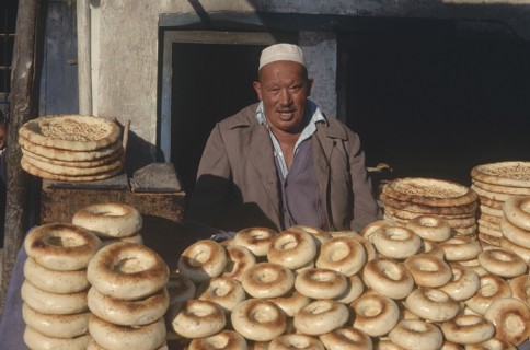 CHINA, Xinjiang, Kashgar, Baker selling bread from a street stall