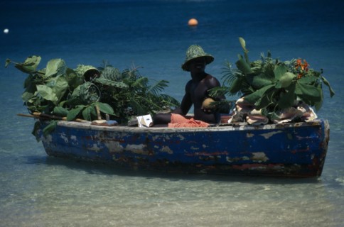 WEST INDIES, St Lucia,  Reduit Beach, Beach vendor selling fruit from boat