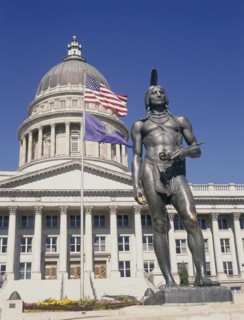 USA, Utah, Salt Lake City, Utah State Capitol.  Detail of dome and colonnaded facade.  Flags flying