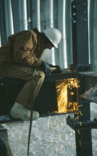 CONSTRUCTION, Welding, "Man wearing protective hat and clothing, welding on a metal structure at