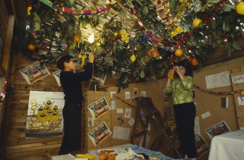SOCIETY, Religion, Judaism, England.  Jewish children decorating the ceiling of a Sukka with cut