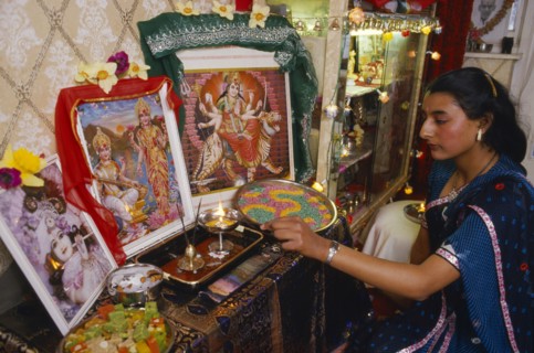 SOCIETY, Religion, Hinduism, England.  Girl lighting candles at home during Dirwali.
