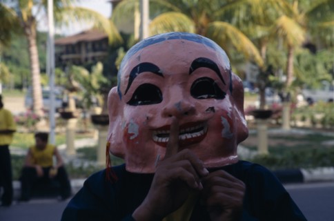 MALAYSIA, Kedah, Langkawi, Masked Chinese New Year Dragon Dance performer with his finger to the