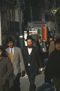 USA, New York State, New York, Orthodox Jewish man walking among other people on 47th Street.